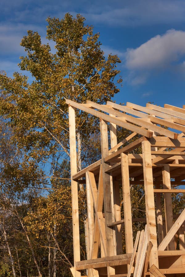 Roof beams. Sunny autumnal evening at the construction site of a wooden house. Unfinished house. Roof beams. Sunny autumnal evening at the construction site of a wooden house. Unfinished house