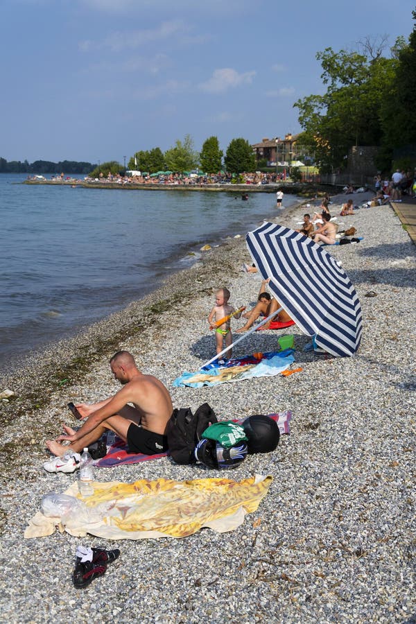 Люди загорая на пляже 30-ого июля 2016 в Desenzano del Garda, Италии стоковое фото Люди загорая на пляже 30-ого июля 2016 в Desenzano del Garda, Италии стоковое фото