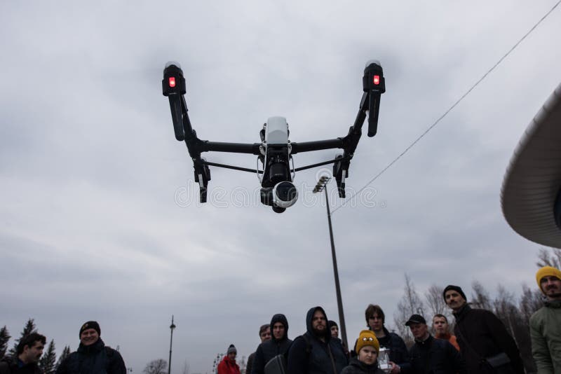 Saint-Petersburg, Russia - 26 MARCH 2016; People watch the flight of Dji Inspire 1 drone UAV quadcopter which shoots 4k video and 12mp still images and is controlled by wireless remote with a range of 4km. Saint-Petersburg, Russia - 26 MARCH 2016; People watch the flight of Dji Inspire 1 drone UAV quadcopter which shoots 4k video and 12mp still images and is controlled by wireless remote with a range of 4km