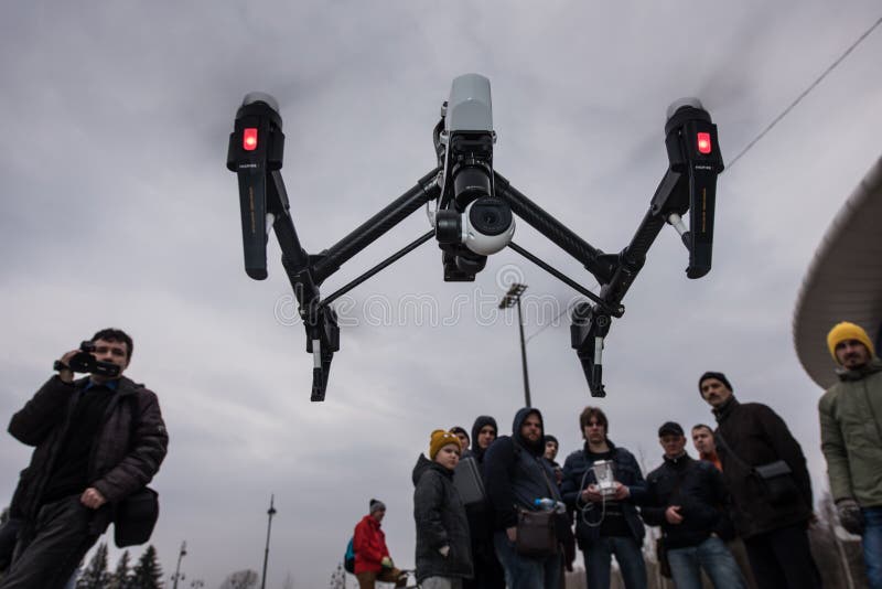 Saint-Petersburg, Russia - 26 MARCH 2016; People watch the flight of Dji Inspire 1 drone UAV quadcopter which shoots 4k video and 12mp still images and is controlled by wireless remote with a range of 4km. Saint-Petersburg, Russia - 26 MARCH 2016; People watch the flight of Dji Inspire 1 drone UAV quadcopter which shoots 4k video and 12mp still images and is controlled by wireless remote with a range of 4km