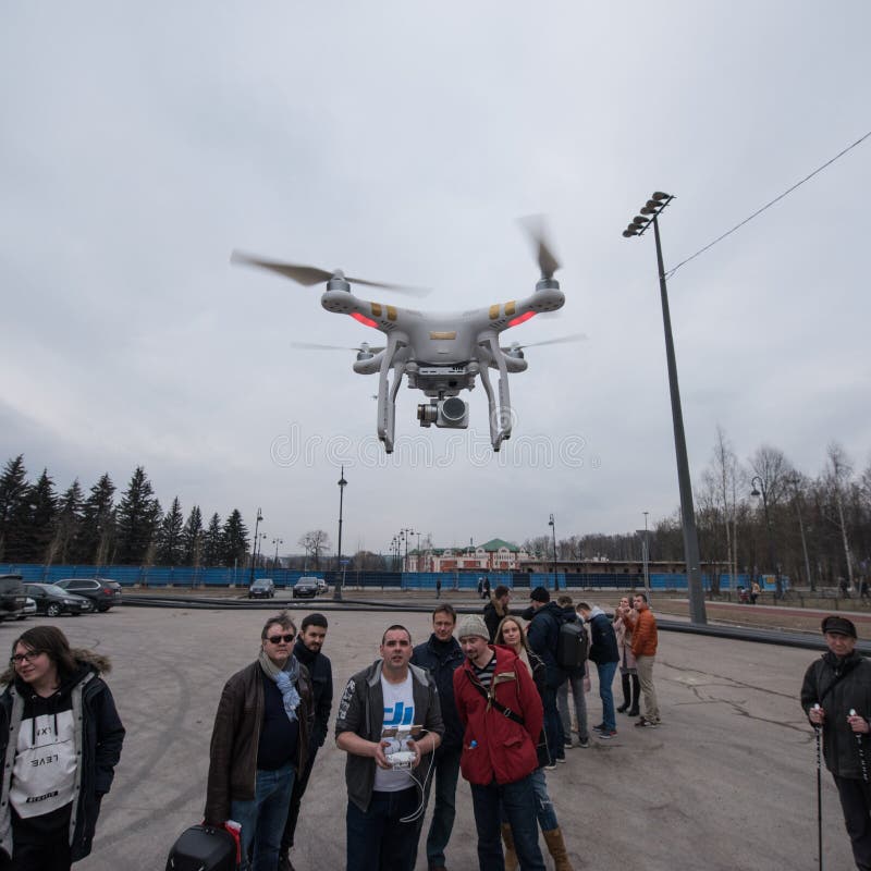 Saint-Petersburg, Russia - 26 MARCH 2016; People watch the flight of Dji Inspire 1 drone UAV quadcopter which shoots 4k video and 12mp still images and is controlled by wireless remote with a range of 4km. Saint-Petersburg, Russia - 26 MARCH 2016; People watch the flight of Dji Inspire 1 drone UAV quadcopter which shoots 4k video and 12mp still images and is controlled by wireless remote with a range of 4km