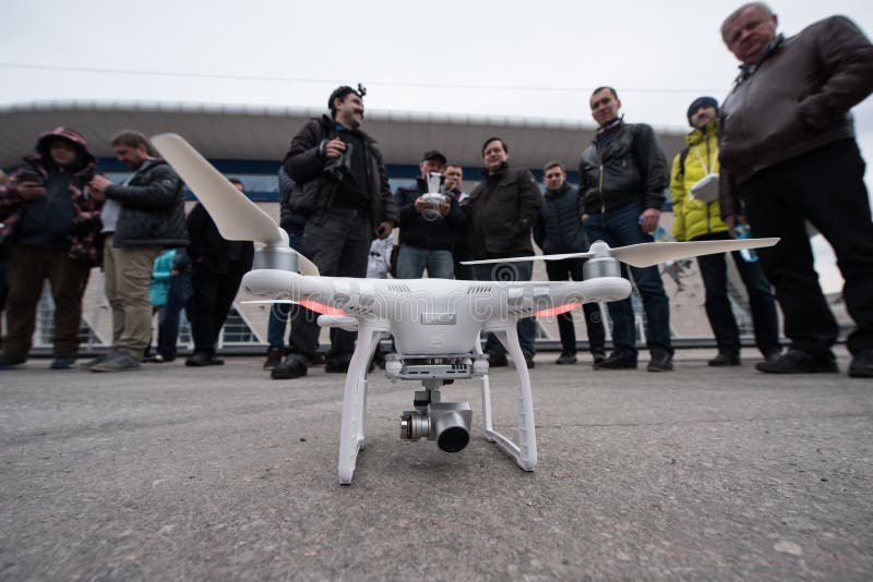 Saint-Petersburg, Russia - 26 MARCH 2016; People watch the flight of Dji Inspire 1 drone UAV quadcopter which shoots 4k video and 12mp still images and is controlled by wireless remote with a range of 4km. Saint-Petersburg, Russia - 26 MARCH 2016; People watch the flight of Dji Inspire 1 drone UAV quadcopter which shoots 4k video and 12mp still images and is controlled by wireless remote with a range of 4km