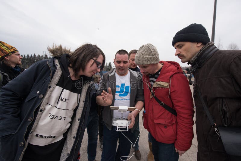 Saint-Petersburg, Russia - 26 MARCH 2016; People watch the flight of Dji Inspire 1 drone UAV quadcopter which shoots 4k video and 12mp still images and is controlled by wireless remote with a range of 4km. Saint-Petersburg, Russia - 26 MARCH 2016; People watch the flight of Dji Inspire 1 drone UAV quadcopter which shoots 4k video and 12mp still images and is controlled by wireless remote with a range of 4km