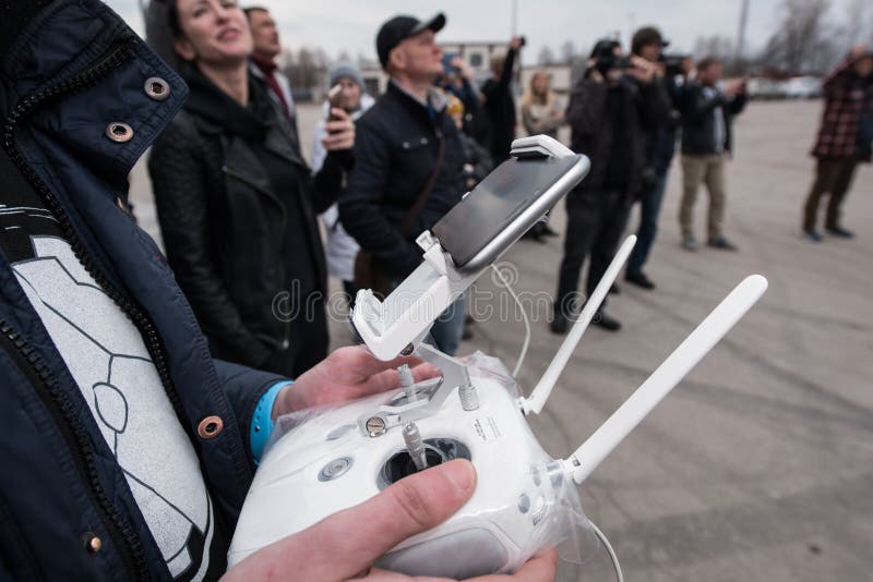 Saint-Petersburg, Russia - 26 MARCH 2016; People watch the flight of Dji Inspire 1 drone UAV quadcopter which shoots 4k video and 12mp still images and is controlled by wireless remote with a range of 4km. Saint-Petersburg, Russia - 26 MARCH 2016; People watch the flight of Dji Inspire 1 drone UAV quadcopter which shoots 4k video and 12mp still images and is controlled by wireless remote with a range of 4km