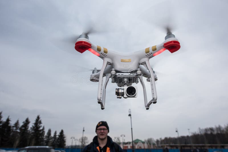 Saint-Petersburg, Russia - 26 MARCH 2016; People watch the flight of Dji Inspire 1 drone UAV quadcopter which shoots 4k video and 12mp still images and is controlled by wireless remote with a range of 4km. Saint-Petersburg, Russia - 26 MARCH 2016; People watch the flight of Dji Inspire 1 drone UAV quadcopter which shoots 4k video and 12mp still images and is controlled by wireless remote with a range of 4km