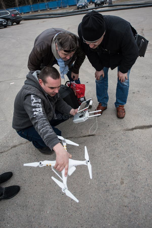 Saint-Petersburg, Russia - 26 MARCH 2016; People watch the flight of Dji Inspire 1 drone UAV quadcopter which shoots 4k video and 12mp still images and is controlled by wireless remote with a range of 4km. Saint-Petersburg, Russia - 26 MARCH 2016; People watch the flight of Dji Inspire 1 drone UAV quadcopter which shoots 4k video and 12mp still images and is controlled by wireless remote with a range of 4km