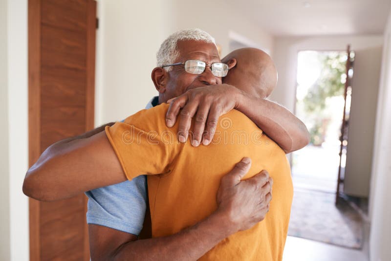 Loving Senior Father Hugging Adult Son Indoors At Home. Loving Senior Father Hugging Adult Son Indoors At Home