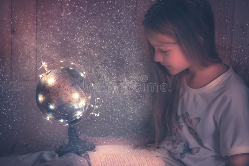 Любознательная восхищаясь девушка ребенк с книгой в кровати мечтая о проявителе образования знания любопытства астрономии концепц стоковое изображение rf Любознательная восхищаясь девушка ребенк с книгой в кровати мечтая о проявителе образования знания любопытства астрономии концепц стоковое изображение rf