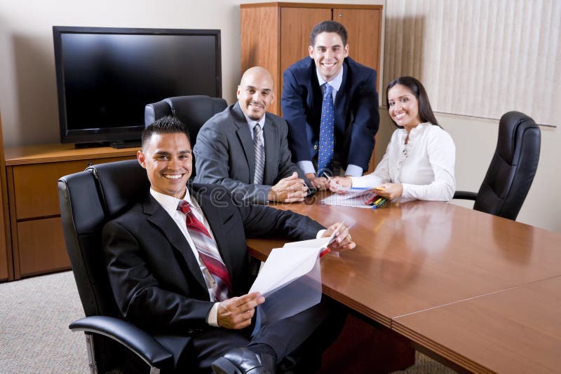 Hispanic business people meeting in boardroom, focus on man in foreground. Hispanic business people meeting in boardroom, focus on man in foreground