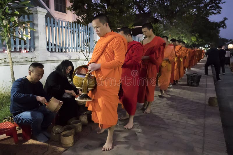 Люди давая милостыни буддийским монахам на улице, Luang Prabang, Лаосе стоковая фотография rf Люди давая милостыни буддийским монахам на улице, Luang Prabang, Лаосе стоковая фотография rf