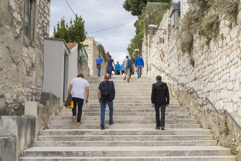 Люди идя в лестницы в городке Sibenik Хорватии