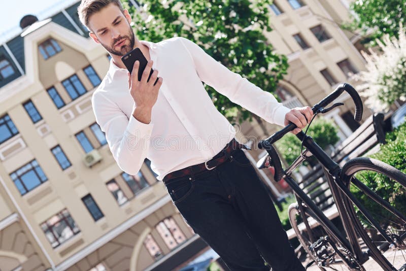 Люди, сообщение, технология, отдых и образ жизни - человек битника с smartphone на телефоне фиксированного велосипеда шестерни бе стоковое фото rf Люди, сообщение, технология, отдых и образ жизни - человек битника с smartphone на телефоне фиксированного велосипеда шестерни бе стоковое фото rf