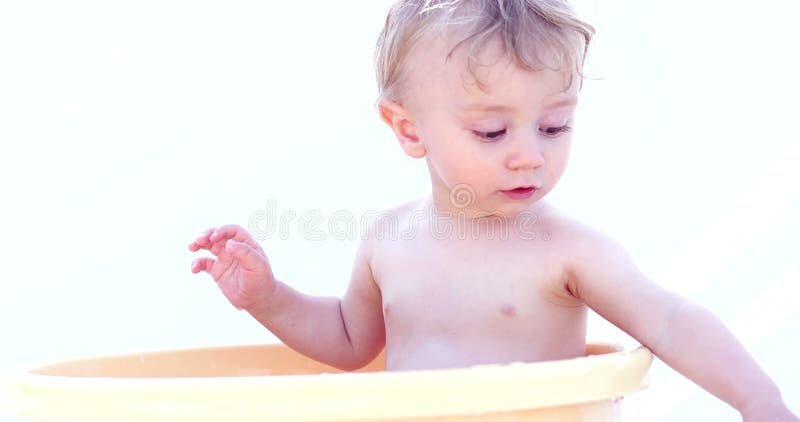 младенец счастливый немногая Ребенок играя в шаре с водой