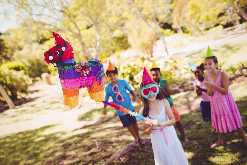 Маленькая девочка идет сломала pinata для их дня рождения стоковая фотография
