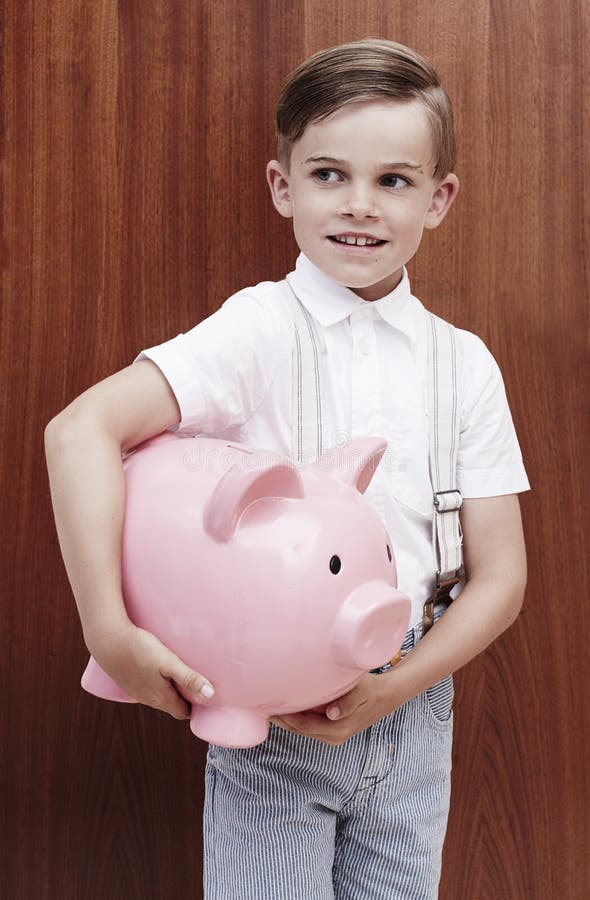 Young boy in braces holing large piggy bank. Young boy in braces holing large piggy bank