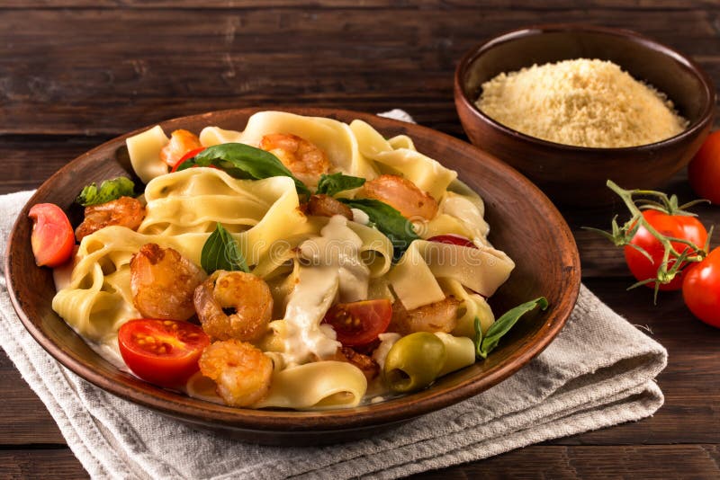 Макаронные изделия Fettuccine с креветкой и томатами на старой таблице стоковые фото Макаронные изделия Fettuccine с креветкой и томатами на старой таблице стоковые фото