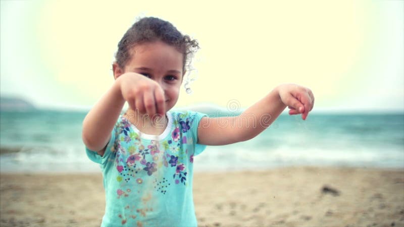 Маленькая девочка на пляже, счастливый маленький младенец играя с песком на пляже Ребенок, ребенок, дети, эмоции