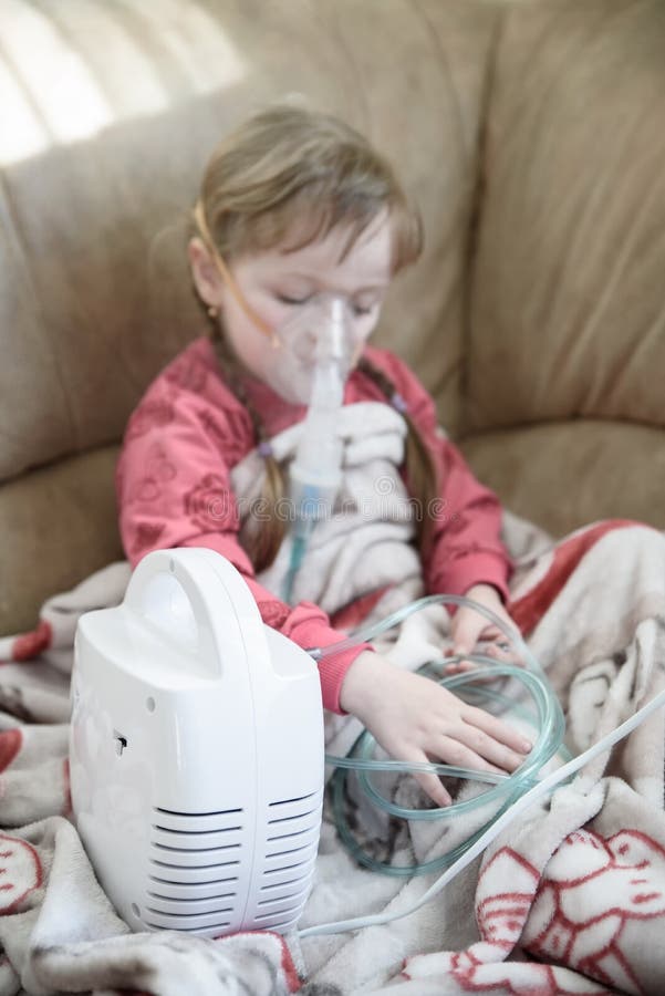 Маленькая девочка обрабатывает жидкий нос используя nebulizer, обработку дома стоковые фото Маленькая девочка обрабатывает жидкий нос используя nebulizer, обработку дома стоковые фото