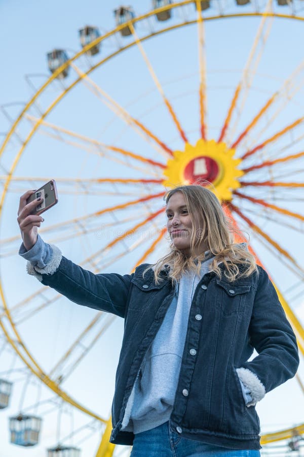 Маленькая девочка принимает selfie перед carousel на Dom гамбургера стоковые изображения rf Маленькая девочка принимает selfie перед carousel на Dom гамбургера стоковые изображения rf