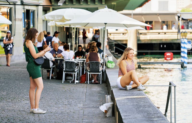 Маленькие девочки принимая фото на набережную реки Limmat в Цюрихе стоковые фотографии rf Маленькие девочки принимая фото на набережную реки Limmat в Цюрихе стоковые фотографии rf