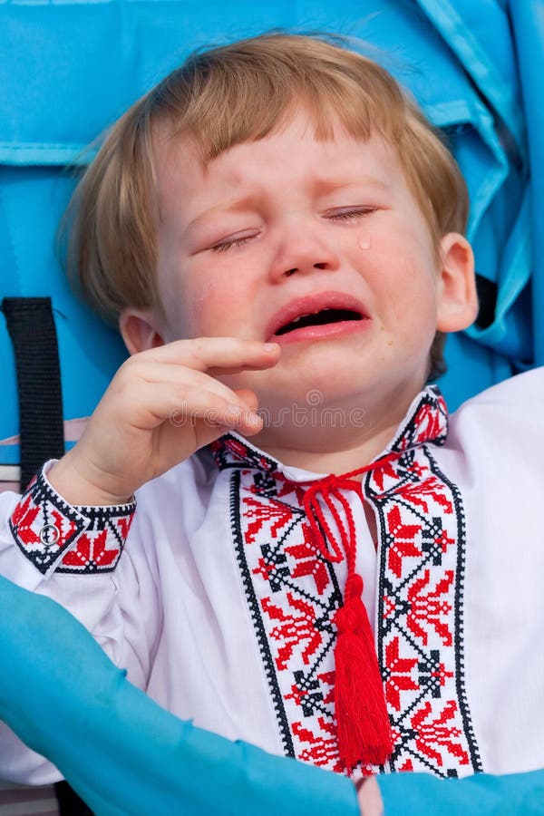 Малый мальчик в украинской рубашке плача в экипаже стоковые фото