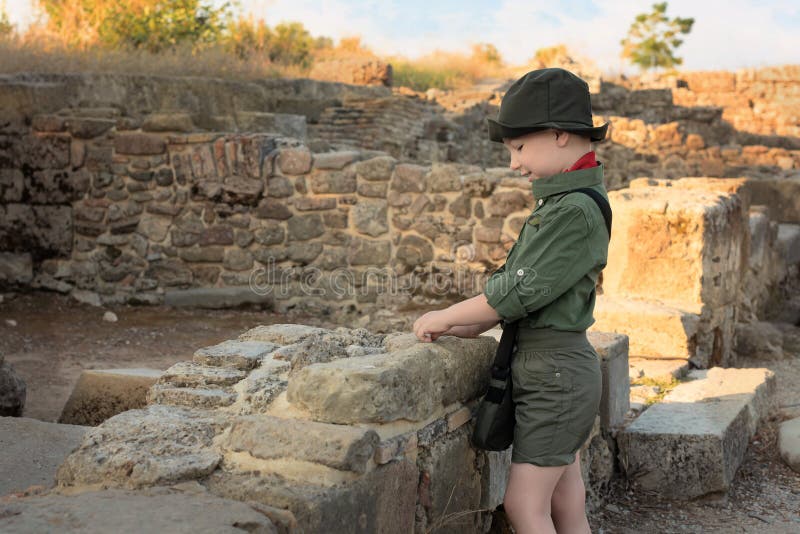 Boy archaeologist in khaki clothes studying the ruins of an ancient city. Diverse, non-traditional jobs concept. Boy archaeologist in khaki clothes studying the ruins of an ancient city. Diverse, non-traditional jobs concept.