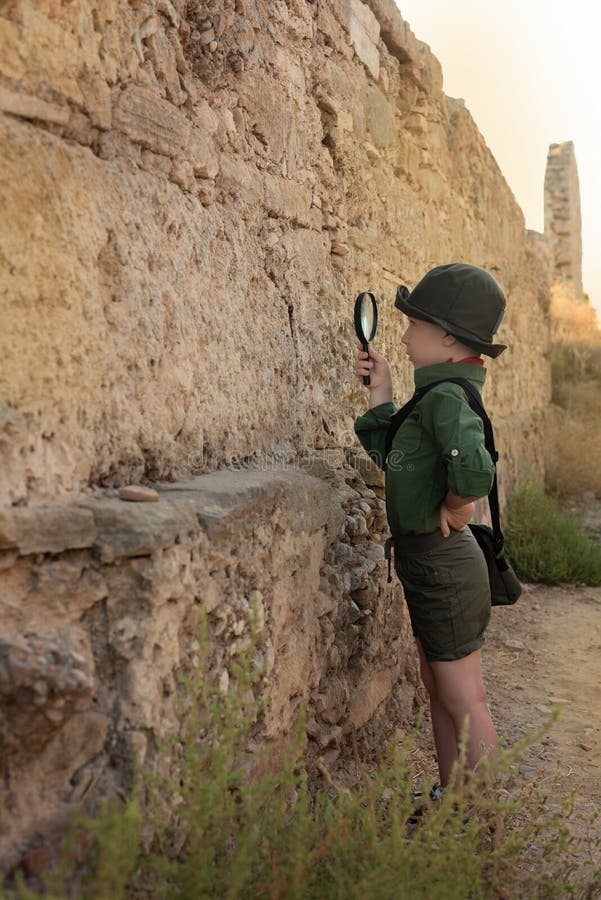 Boy archaeologist in khaki clothes studying the ruins of an ancient city. Diverse, non-traditional jobs concept. Boy archaeologist in khaki clothes studying the ruins of an ancient city. Diverse, non-traditional jobs concept.