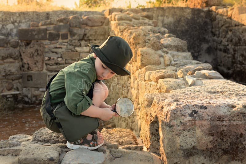 Boy archaeologist in khaki clothes studying the ruins of an ancient city. Diverse, non-traditional jobs concept. Boy archaeologist in khaki clothes studying the ruins of an ancient city. Diverse, non-traditional jobs concept.