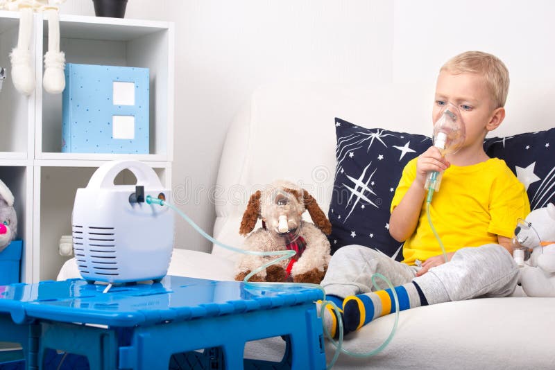 Мальчик делает вдыхание с nebulizer Домашняя обработка Ребенок и собака игрушки в масках стоковая фотография Мальчик делает вдыхание с nebulizer Домашняя обработка Ребенок и собака игрушки в масках стоковая фотография