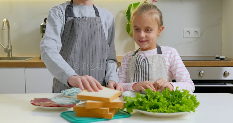 мальчик и девочка делают бутерброды на кухне. стоковое фото