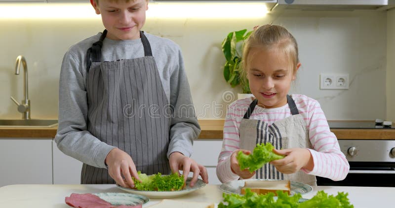 мальчик и девочка делают бутерброды на кухне. стоковое фото