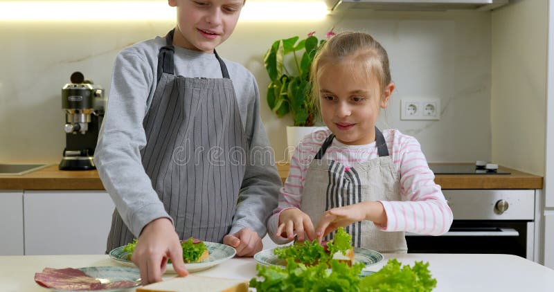 мальчик и девочка делают бутерброды на кухне. стоковые фото