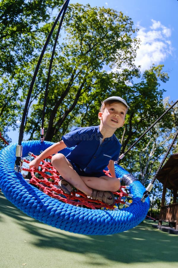 Мальчик на swing ребенка парка счастливое детство детской площадки на девушке стоковые фото