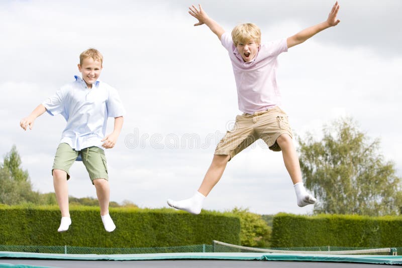 мальчики скача сь детеныши trampoline 2 стоковые фотографии rf мальчики скача сь детеныши trampoline 2 стоковые фотографии rf