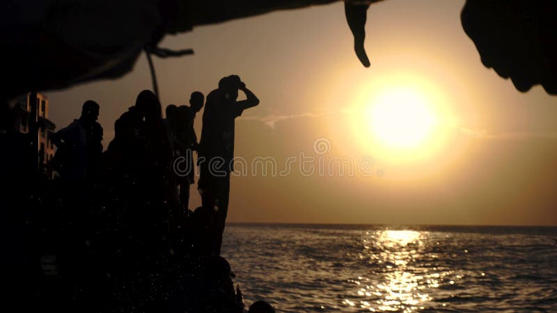Мальчики черного африканского Занзибар полной воды каждый день, как правило, прыгая в воду океана от каменного embarkment и