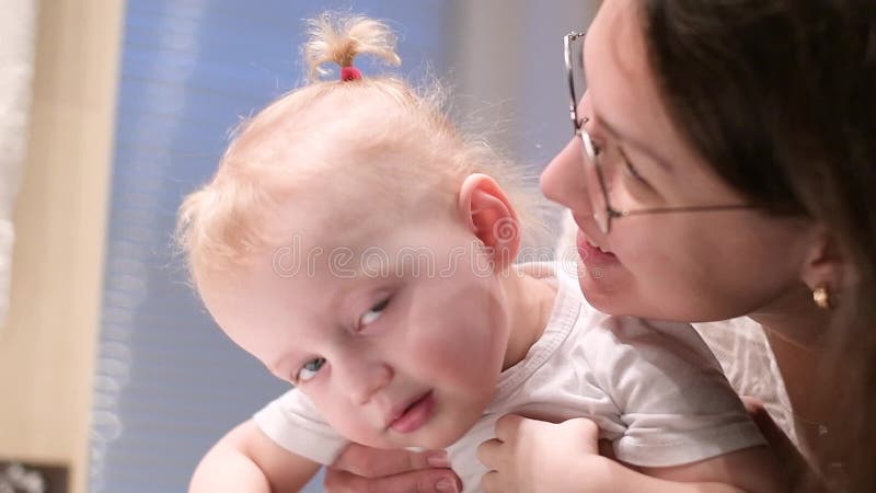 Мама и маленькие объятие и поцелуй дочери в ванной