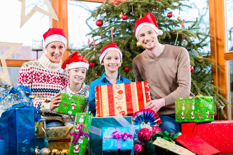 Мама, папа и сыновьья на X-mas во время вручать из настоящих моментов стоковая фотография rf