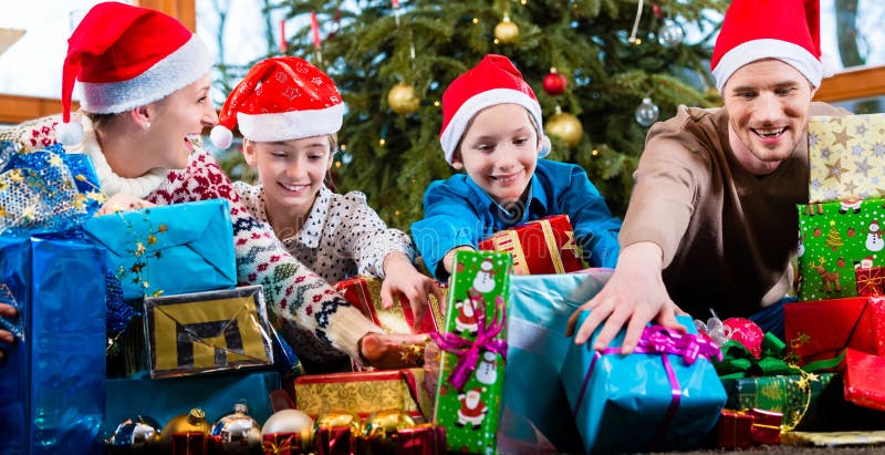 Мама, папа и сыновьья на X-mas во время вручать из настоящих моментов стоковое изображение rf