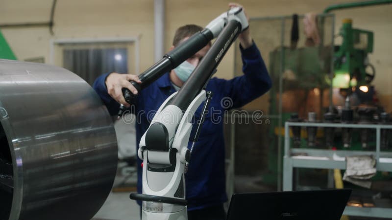 20210923 мариупольский кран. фабрика магма. техник в синей форме калибрует крупногабаритное оборудование с помощью портативных акции видеоматериалы