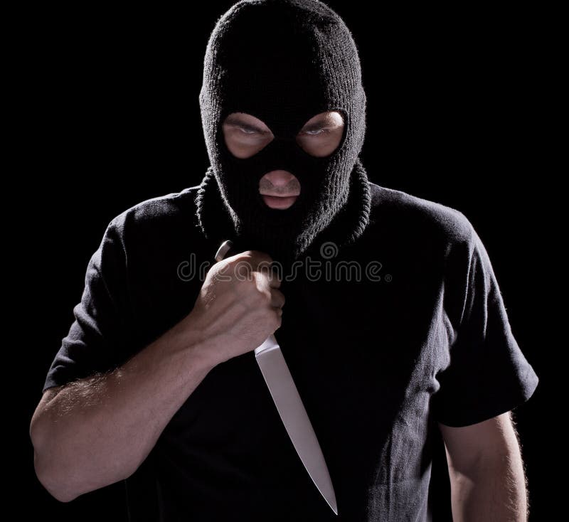 Burglar in mask holding knife on black background. Burglar in mask holding knife on black background