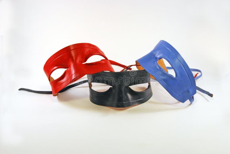 Three leather Lone Ranger type masks, red, black and blue, against a white background. Three leather Lone Ranger type masks, red, black and blue, against a white background