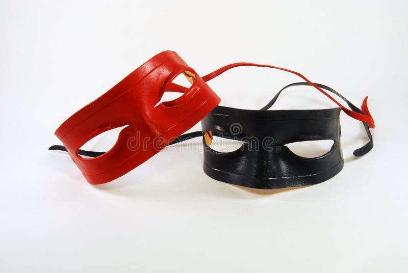 Two leather Lone Ranger type masks, red and black, isolated against a white background. Two leather Lone Ranger type masks, red and black, isolated against a white background
