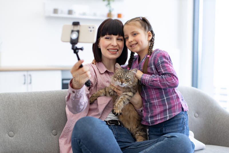 мать и дочь делают селфи с кошкой дома стоковые фотографии rf