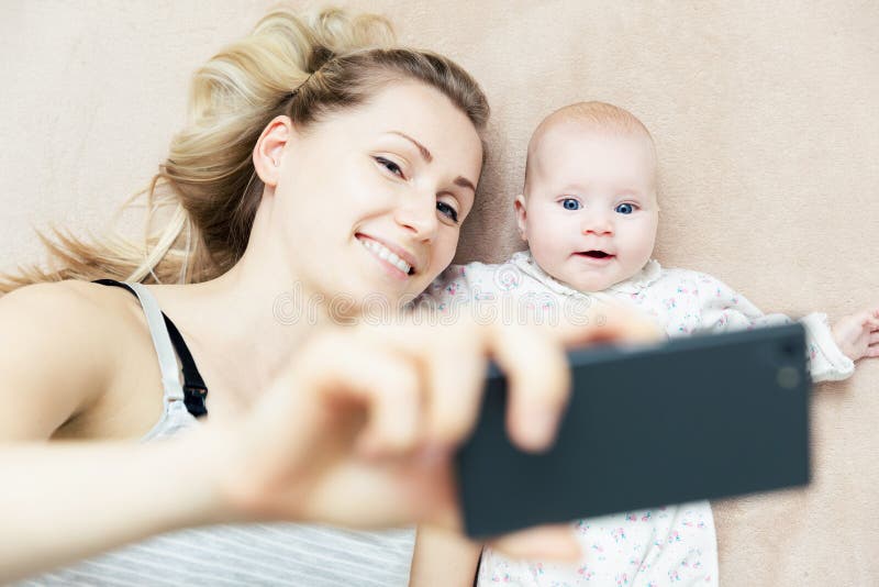 Мать и маленький младенческий младенец принимая selfie с телефоном стоковое изображение