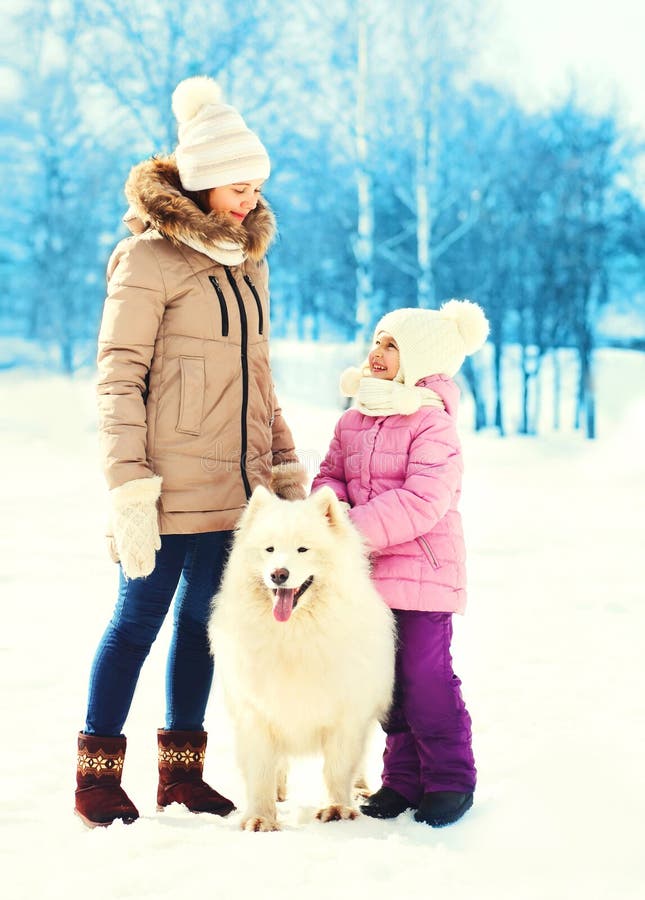 Мать и ребенок с белым Samoyed выслеживают идти в зиму стоковое фото Мать и ребенок с белым Samoyed выслеживают идти в зиму стоковое фото
