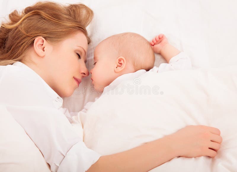 Мать обнимает newborn младенца совместно в кровати стоковая фотография rf