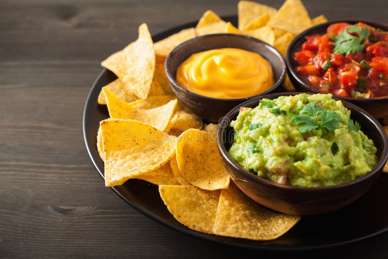 Мексиканские обломоки tortilla nachos с гуакамоле, сальсой и сыром d стоковая фотография Мексиканские обломоки tortilla nachos с гуакамоле, сальсой и сыром d стоковая фотография
