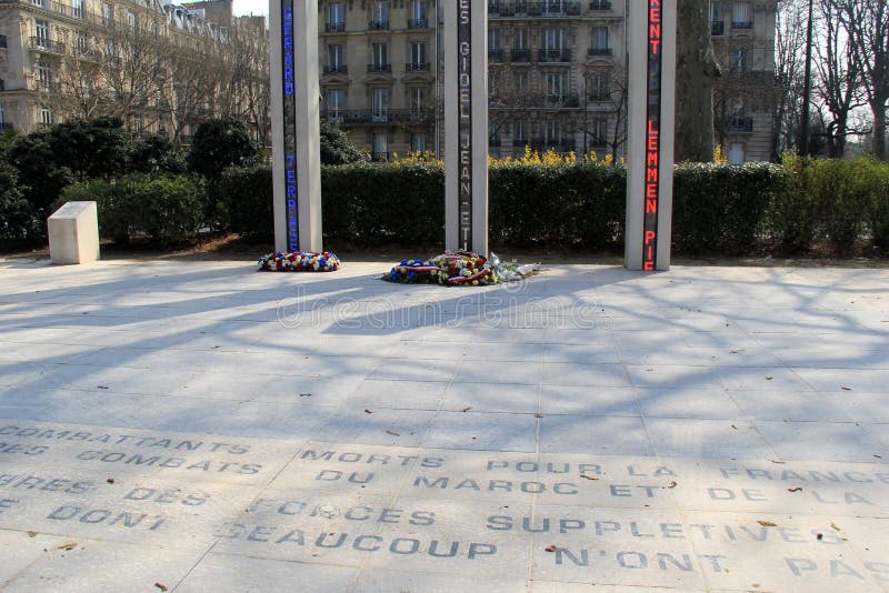 Мемориальный вне Эйфелева башни, при цветки помещенные под высокорослыми столбцами, Париж, Франция, 2016