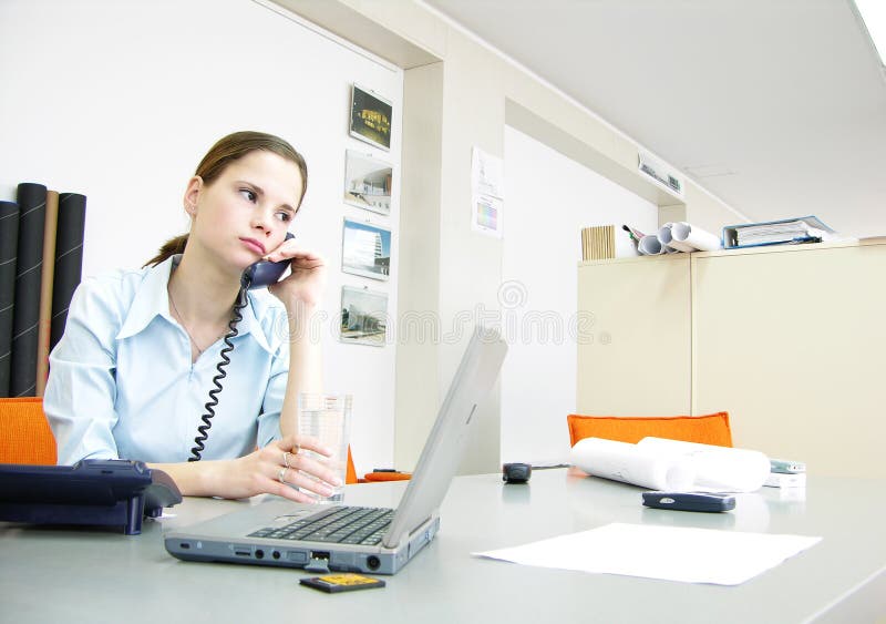 A regular office scene. Woman speaking at the phone. A regular office scene. Woman speaking at the phone.