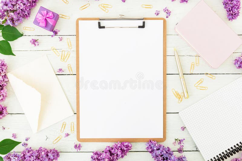 Место для работы Minimalistic с доской сзажимом для бумаги, конвертом, сиренью и аксессуарами на белой предпосылке Фрилансер или стоковое фото rf Место для работы Minimalistic с доской сзажимом для бумаги, конвертом, сиренью и аксессуарами на белой предпосылке Фрилансер или стоковое фото rf